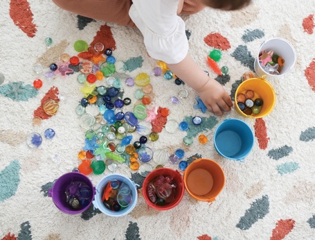 Toddler playing with pebbles at First Roots Early Education Academy - Licensed Child Care in Richmond Hill Toddler playing with pebbles at First Roots Early Education Academy - Licensed Child Care in Richmond Hill