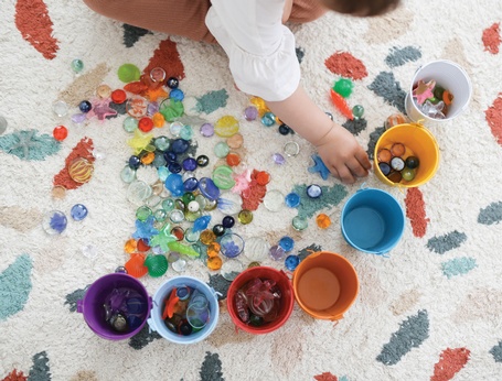 Toddler playing with pebbles at First Roots Early Education Academy - Licensed Child Care in Richmond Hill